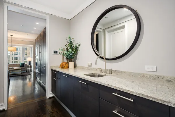 a en suite bathroom with a granite countertop sink and a mirror