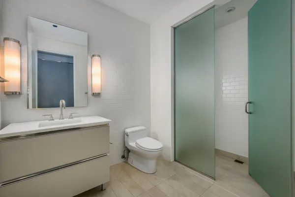 a bathroom with a toilet sink and mirror