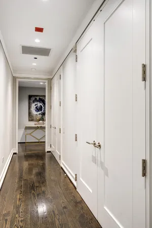 a hallway with wooden floor and closet
