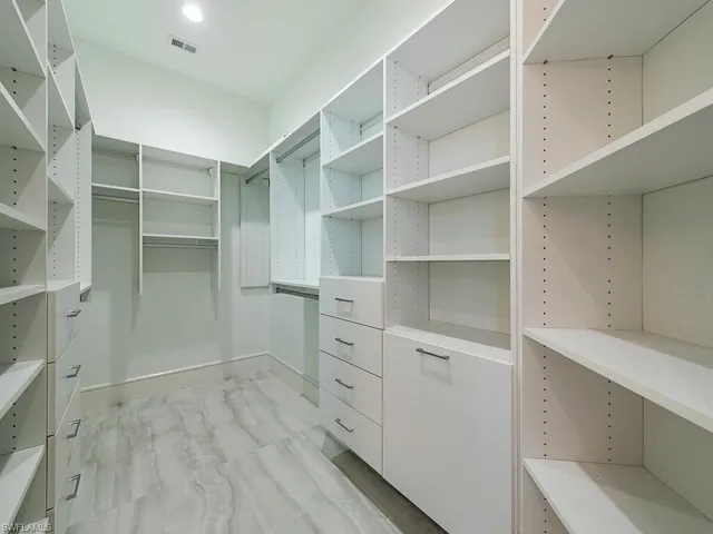a view of walk in closet with empty racks