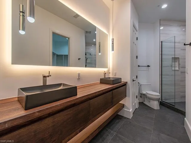 a bathroom with a double vanity sink toilet and shower