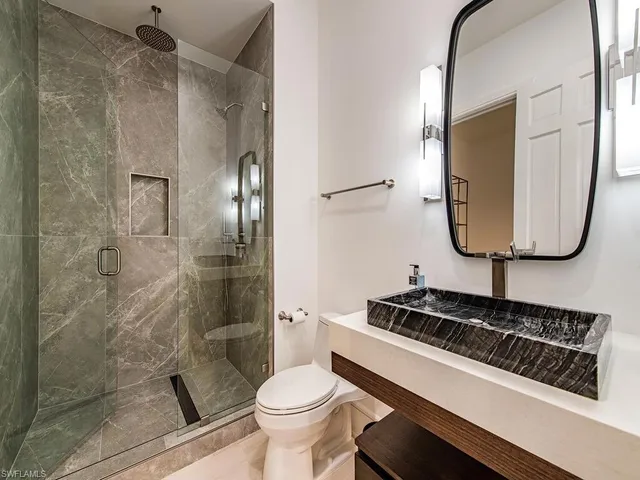 a bathroom with a toilet a sink and a mirror