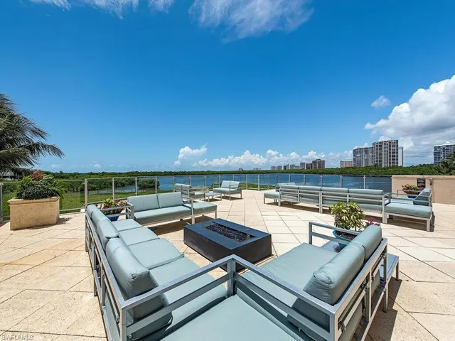 a view of a roof deck with couches and sky view