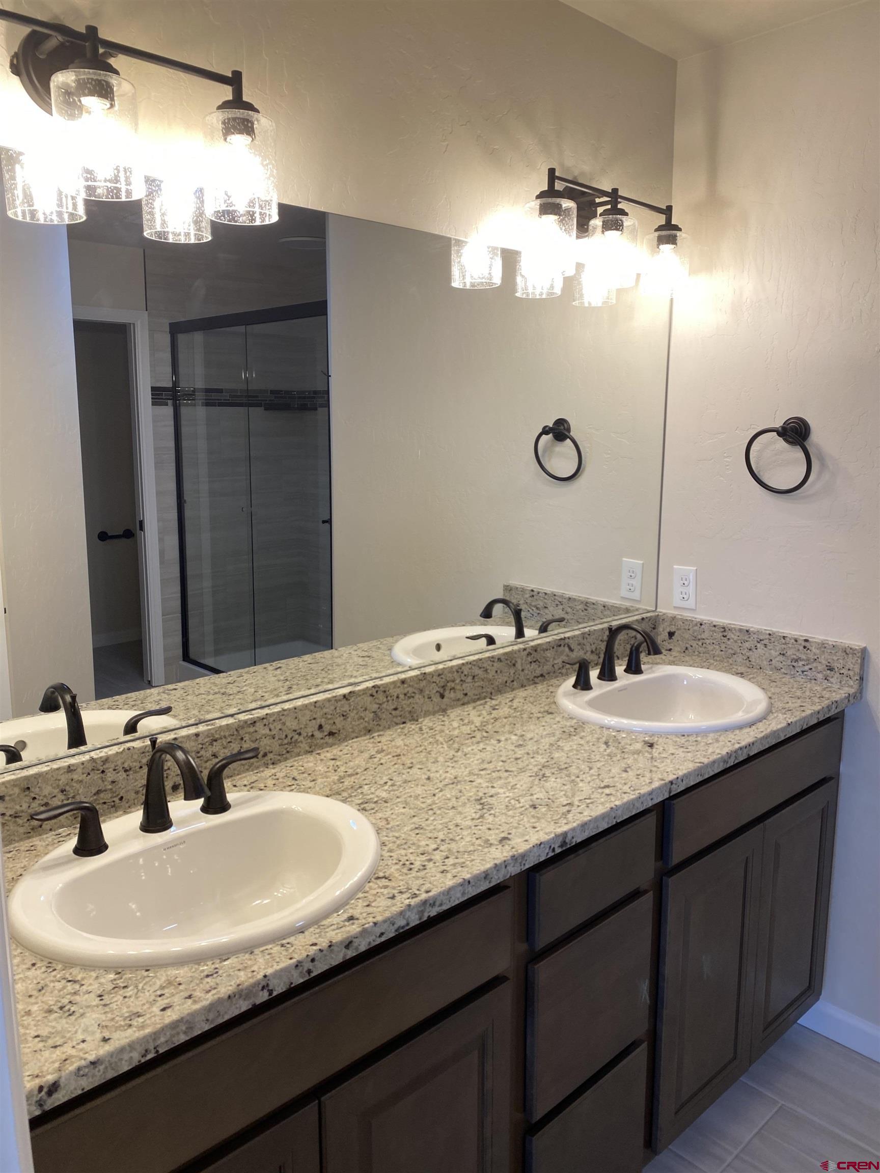 3672 Big Pines Loop Montrose, CO 81401 - Photo 12 of 19 a bathroom with a granite countertop double sink and a mirror