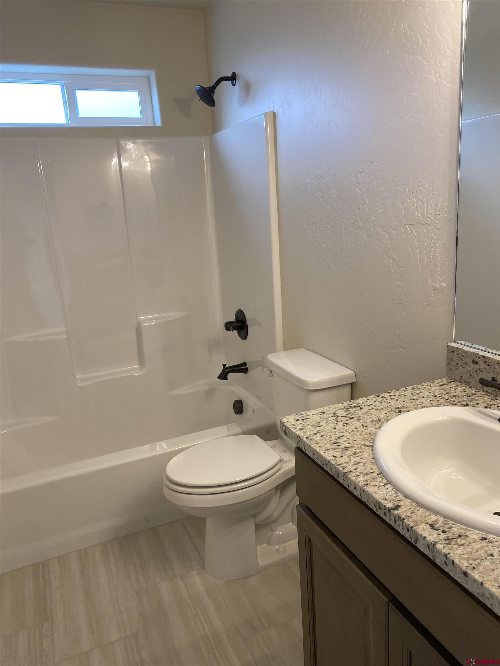 3672 Big Pines Loop Montrose, CO 81401 - Photo 17 of 19 a bathroom with a granite countertop sink toilet and shower