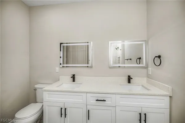 a bathroom with a sink toilet a mirror and vanity