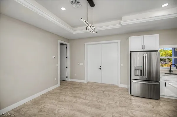a view of a kitchen with a ceiling fan a refrigerator and windows