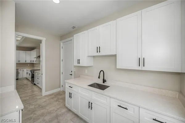 a kitchen with white cabinets and a sink