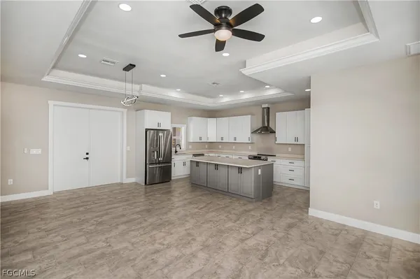 a kitchen with a refrigerator a sink and white cabinets
