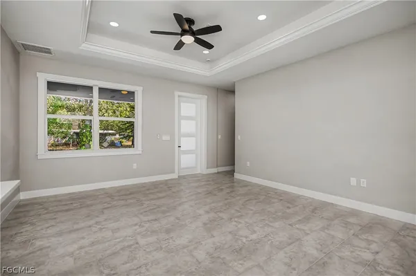 an empty room with windows and ceiling fan