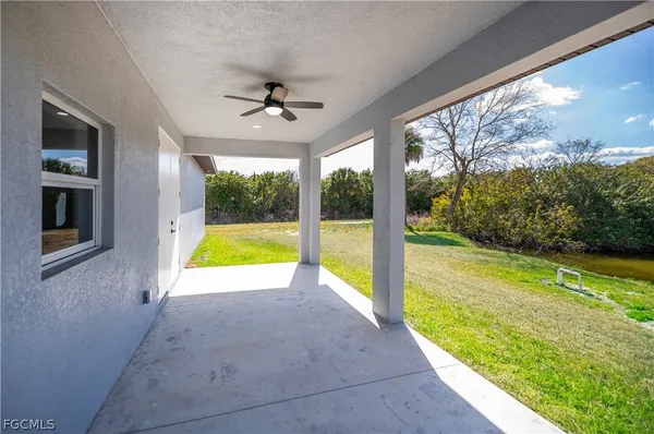 a view of an empty room with a floor to ceiling window and a yard