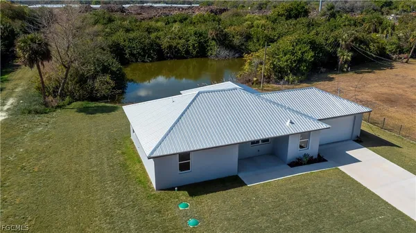 an aerial view of a house with swimming pool and lake view