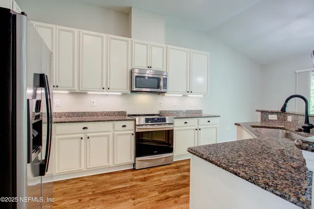 a kitchen with a sink stove and refrigerator