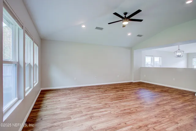 a view of empty room with wooden floor
