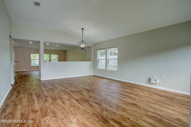 a view of a room with wooden floor and windows
