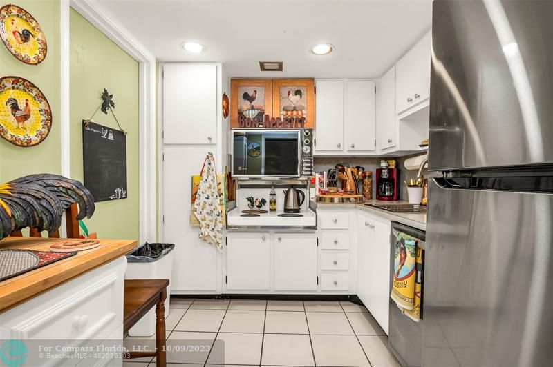 a view of kitchen with stainless steel appliances granite countertop a stove and a refrigerator