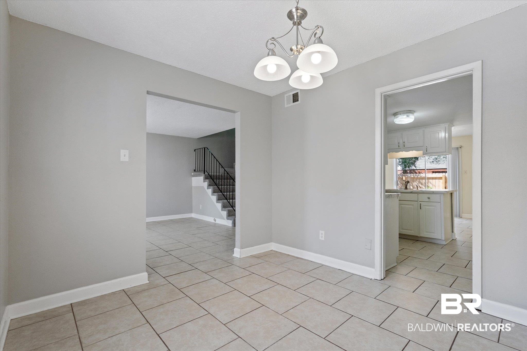 4017 Cottage Hill Road, Unit 59 Mobile, AL 36609 - Photo 5 of 25 Unfurnished dining area with light tile patterned floors and a chandelier