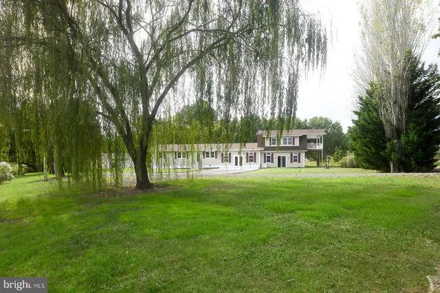 a kitchen with stainless steel appliances granite countertop a refrigerator a sink a stove a microwave and island with wooden floor