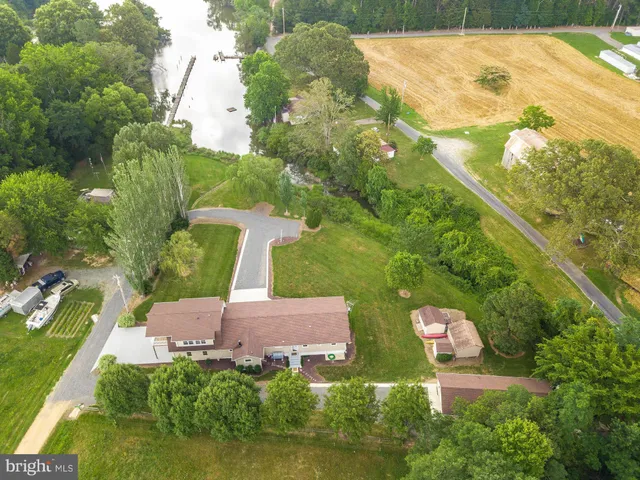 an empty room with wooden floor kitchen view and a window