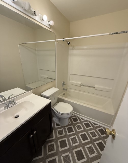 220 Elm Street, Unit 533 Clemson, SC 29631 - Photo 9 of 10 A well-lit full bathroom features a modern vanity, toilet, and a clean tub-shower combination with patterned flooring.