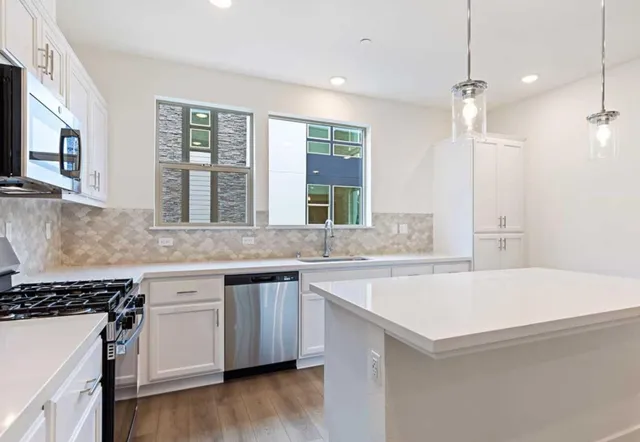 a kitchen with granite countertop a sink and a stove