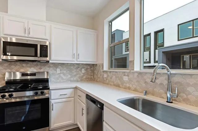 a kitchen with stainless steel appliances granite countertop a sink and a microwave