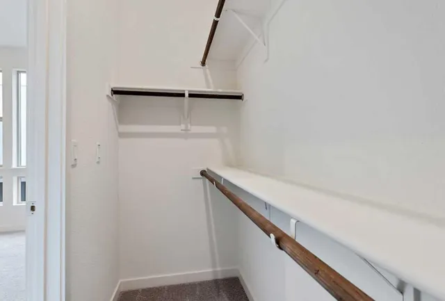 a spacious bathroom with a double vanity sink a toilet and a mirror