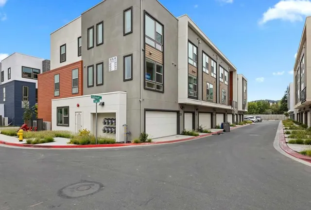 a front view of a multi story residential apartment building with garage and plants