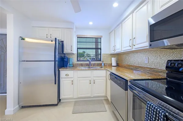 a kitchen with a refrigerator sink and cabinets