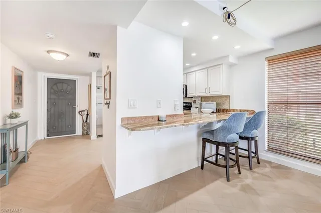 a kitchen with a dining table chairs refrigerator and cabinets