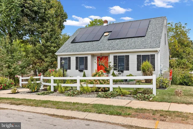 front view of a brick house with a bench in front of it