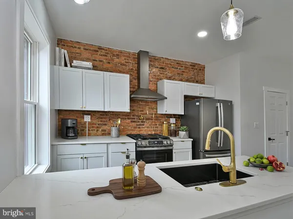 a kitchen with stainless steel appliances granite countertop a sink a refrigerator and a stove
