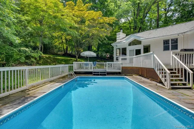 a view of a house with wooden deck and a big yard