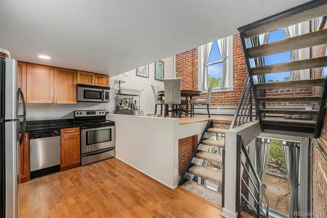 a kitchen with stainless steel appliances kitchen island granite countertop a refrigerator and a stove top oven
