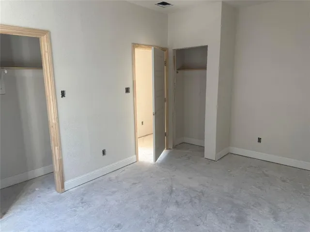 an empty room with closet and a bathroom