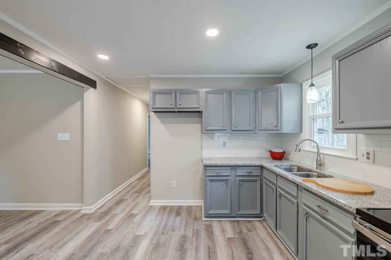 6803 Russell Road Durham, NC 27712 - Photo 11 of 27 a kitchen with a sink cabinets stainless steel appliances and a window