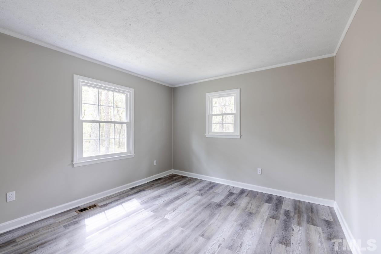 6803 Russell Road Durham, NC 27712 - Photo 16 of 27 an empty room with wooden floor and windows