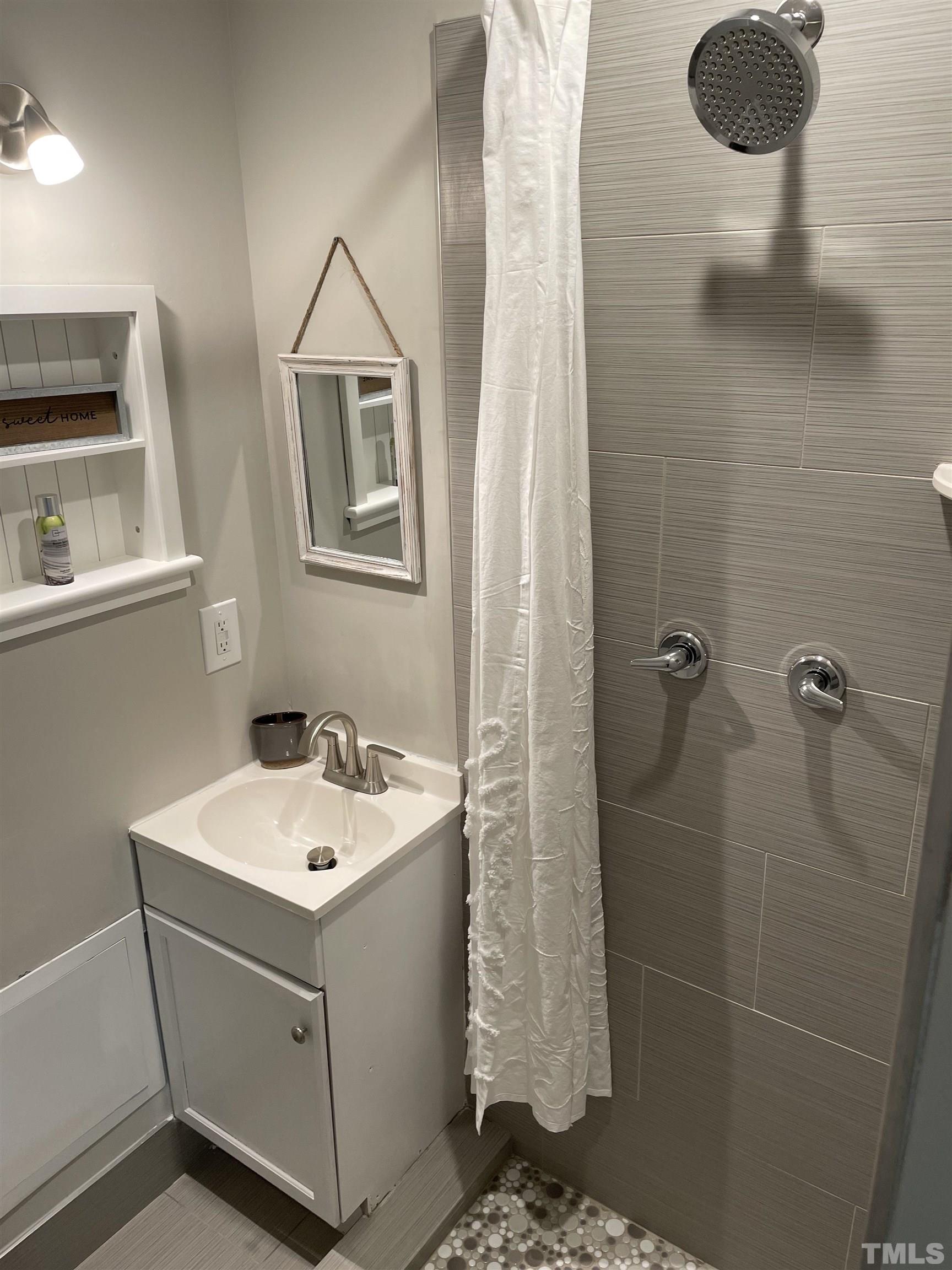 6803 Russell Road Durham, NC 27712 - Photo 17 of 27 a bathroom with a sink and mirror