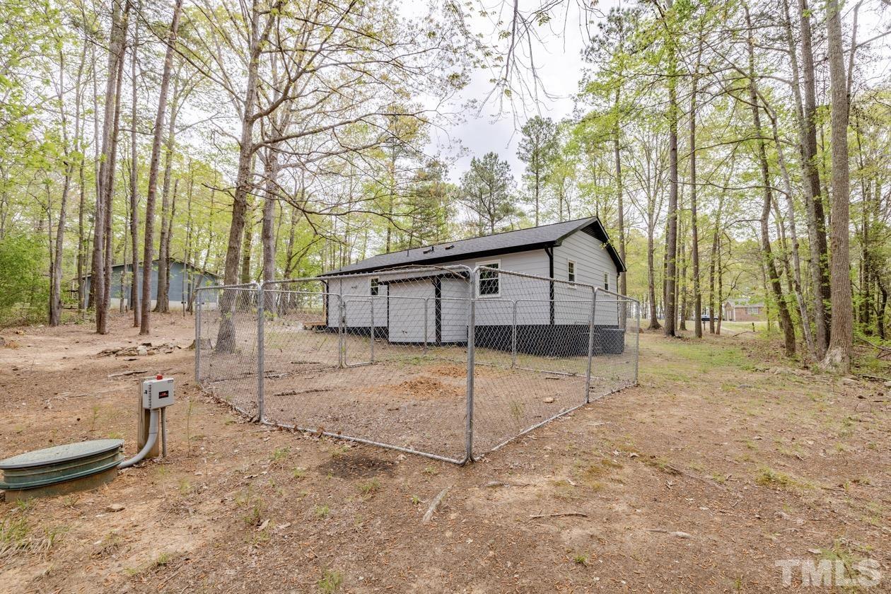 6803 Russell Road Durham, NC 27712 - Photo 24 of 27 a view of a house with a large tree and wooden fence