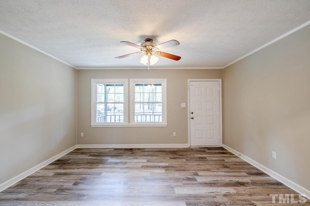 6803 Russell Road Durham, NC 27712 - Photo 3 of 27 a view of a room with window ceiling fan and wooden floor
