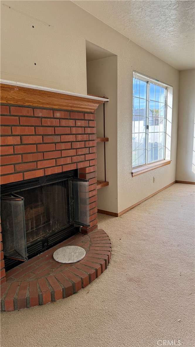 13116 Rincon Road Apple Valley, CA 92308 - Photo 19 of 62 a view of an empty room with window and fireplace