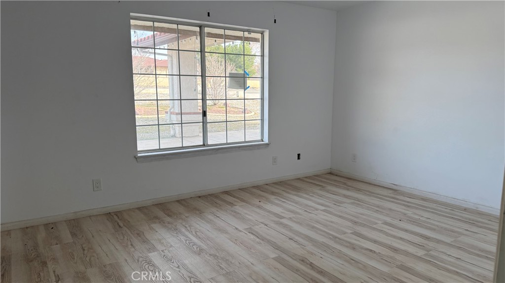 13116 Rincon Road Apple Valley, CA 92308 - Photo 29 of 62 an empty room with wooden floor and windows
