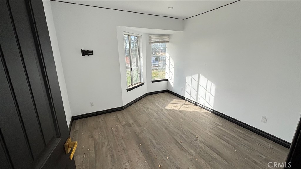 13116 Rincon Road Apple Valley, CA 92308 - Photo 37 of 62 a view of an empty room with wooden floor and a window
