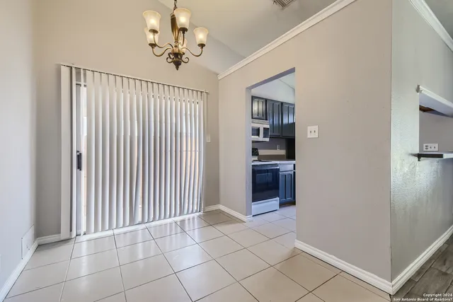 a view of an empty room with a cabinet and a window