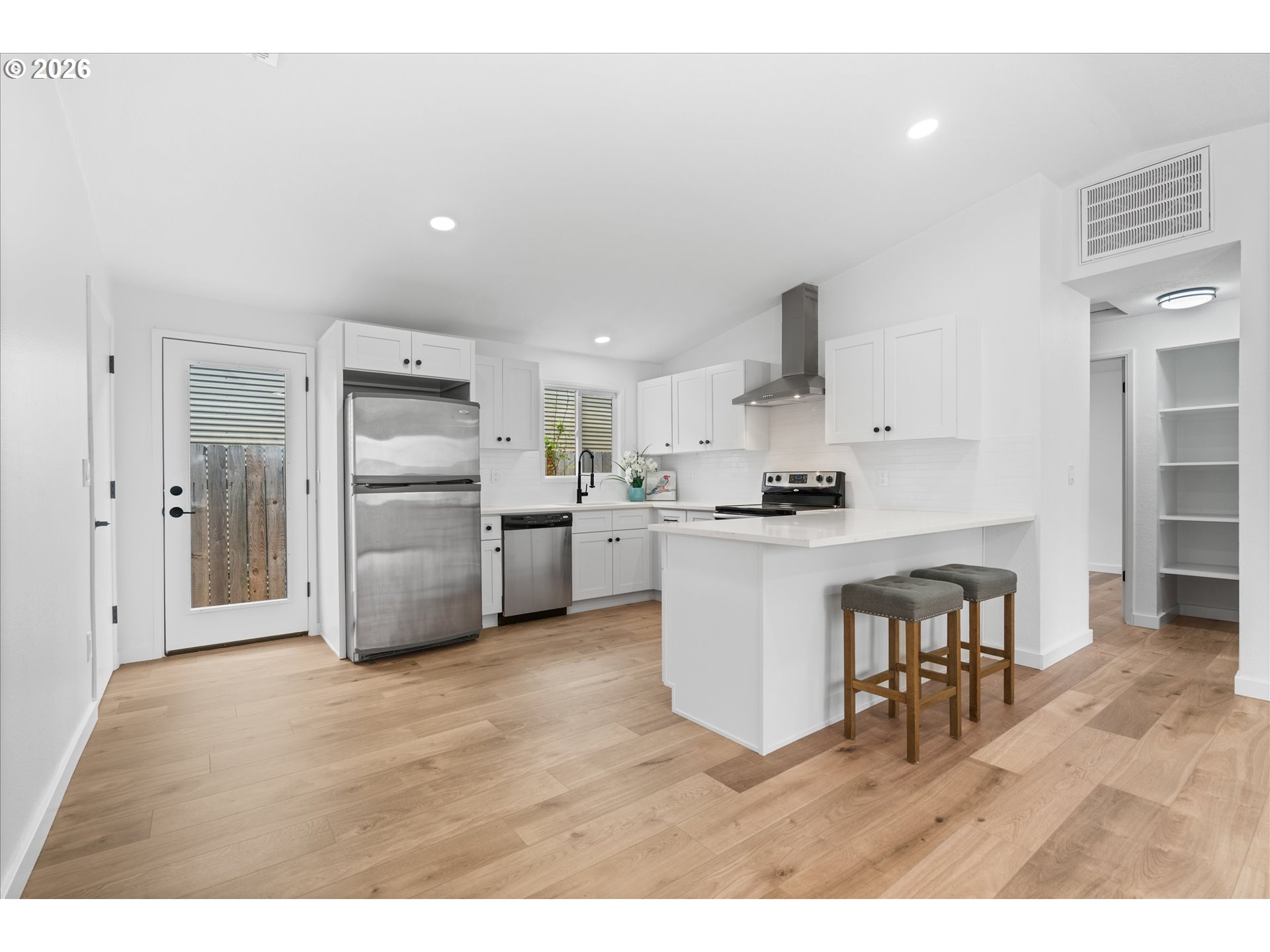 602 South Vermont Street Portland, OR 97219 - Photo 25 of 46 a kitchen with white cabinets and stainless steel appliances