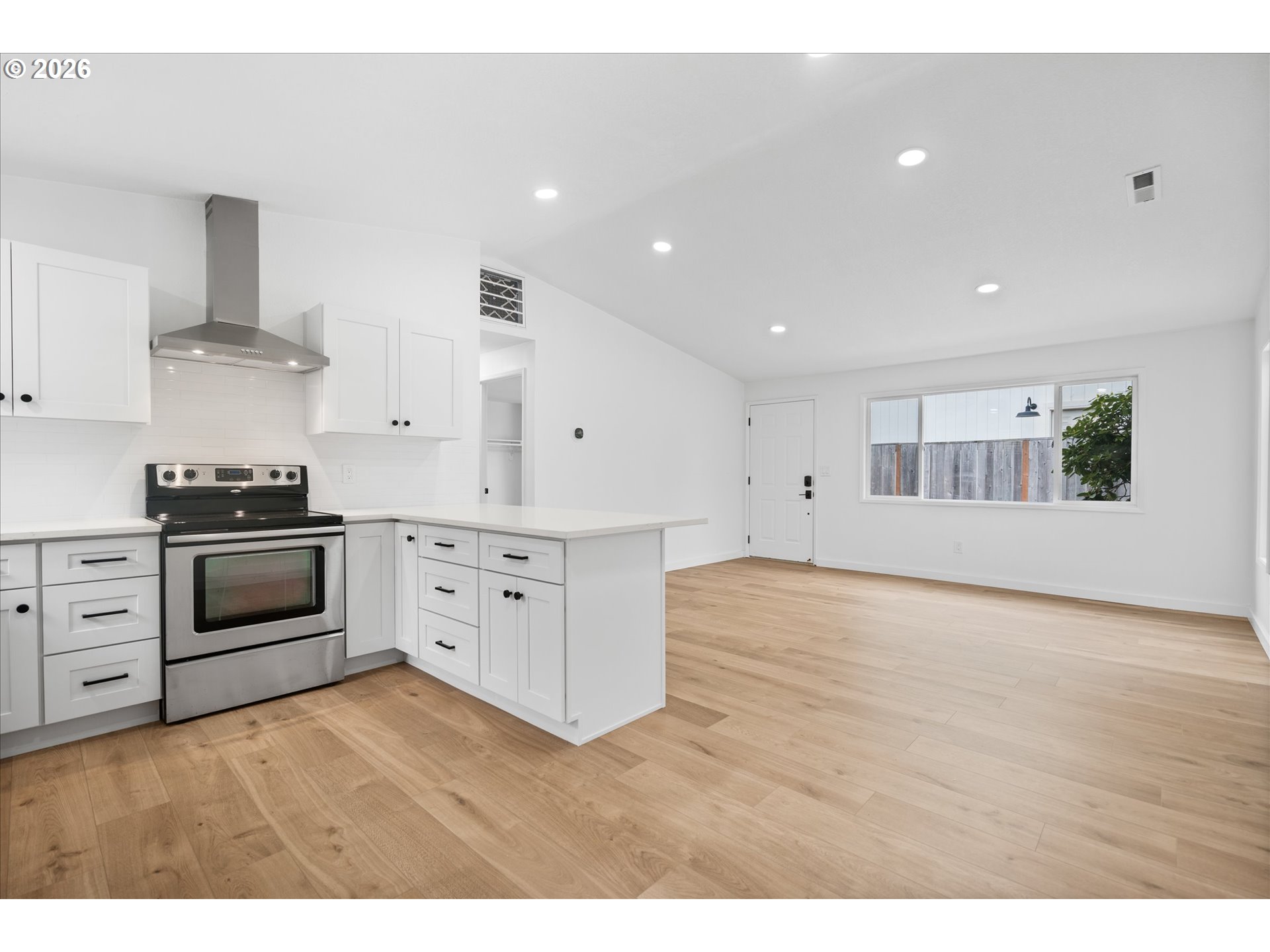 602 South Vermont Street Portland, OR 97219 - Photo 28 of 46 a kitchen with stainless steel appliances white cabinets and wooden floors