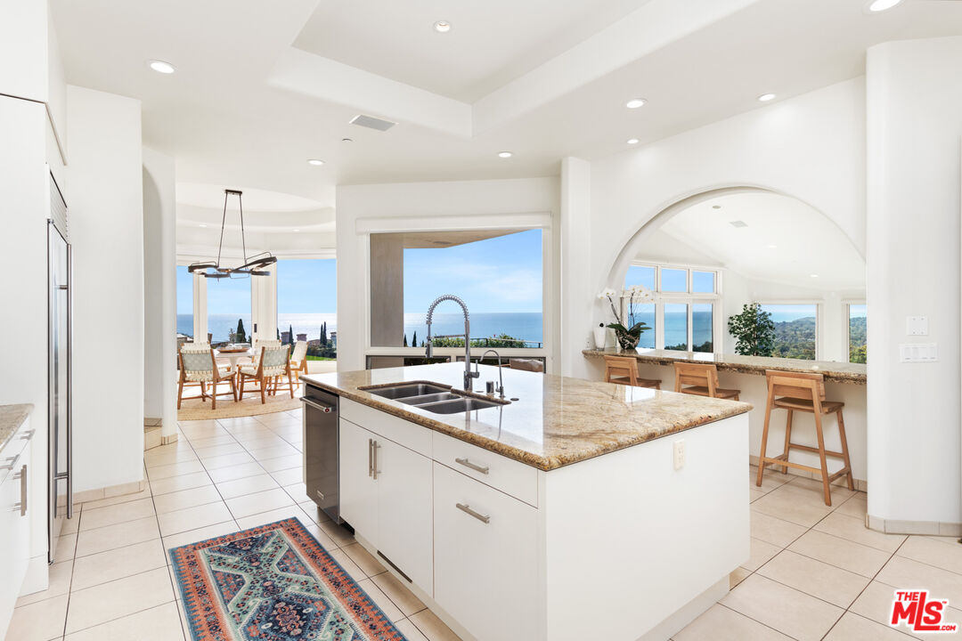 27445 Winding Way Malibu, CA 90265 - Photo 28 of 59 a kitchen with stainless steel appliances granite countertop a sink a stove and a refrigerator