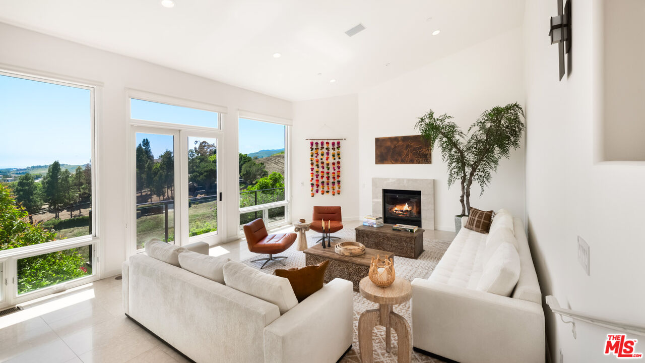 27445 Winding Way Malibu, CA 90265 - Photo 34 of 59 a living room with furniture fireplace and a large window