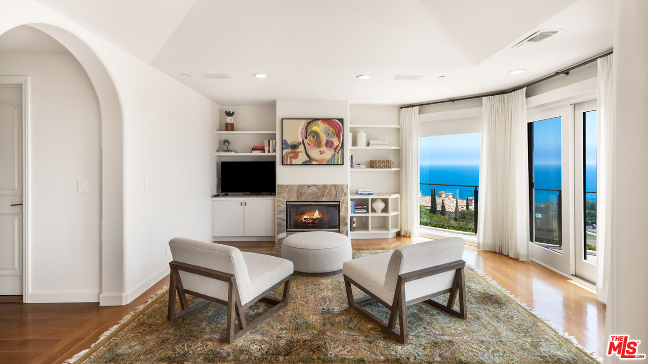 27445 Winding Way Malibu, CA 90265 - Photo 40 of 59 a living room with furniture a flat screen tv and a floor to ceiling window