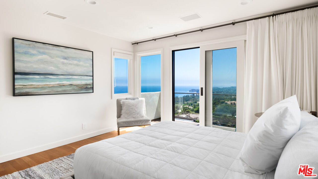 27445 Winding Way Malibu, CA 90265 - Photo 47 of 59 a bedroom with a bed and glass window